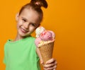 Pretty baby girl kid eating licking banana and strawberry ice cream in waffles cone Royalty Free Stock Photo