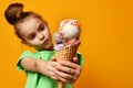 Pretty baby girl kid eating licking banana and strawberry ice cream in waffles cone Royalty Free Stock Photo