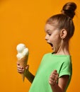 Pretty baby girl kid eating licking banana and vanilla ice cream in waffles cone Royalty Free Stock Photo