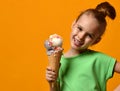 Pretty baby girl kid eating licking vanilla ice cream in waffles cone Royalty Free Stock Photo