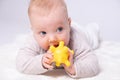 Pretty baby plays on the floor with a toy Royalty Free Stock Photo