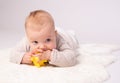 Pretty baby plays on the floor with a toy Royalty Free Stock Photo