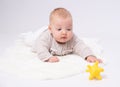 Pretty baby plays on the floor with a toy Royalty Free Stock Photo