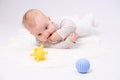 Pretty baby plays on the floor with a toy Royalty Free Stock Photo