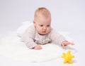 Pretty baby plays on the floor with a toy Royalty Free Stock Photo