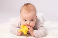 Pretty baby plays on the floor with a toy Royalty Free Stock Photo