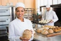 Pretty baker smiling at camera with loaf Royalty Free Stock Photo