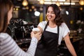 Pretty barista giving disposable cup to woman Royalty Free Stock Photo