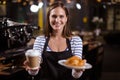 Pretty barista holding disposable cup and brioche Royalty Free Stock Photo