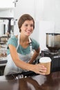 Pretty barista holding disposable cup Royalty Free Stock Photo