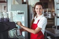 Pretty barista looking at camera and using the coffee machine