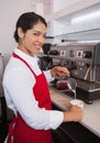 Pretty barista pouring milk into cup of coffee Royalty Free Stock Photo