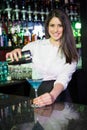 Pretty bartender pouring a blue martini drink in the glass Royalty Free Stock Photo