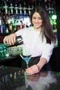 Pretty bartender pouring a blue martini drink in the glass Royalty Free Stock Photo