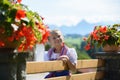 Pretty bavarian girl with flowers on the farm . Alps in background . Germany . Royalty Free Stock Photo