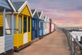 Pretty beach huts at dusk along a promenade in Southwold on the Suffolk coast, UK