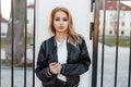 Pretty beautiful young blond woman in a black spring stylish jacket in black jeans in white shirt stands