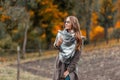 Pretty beautiful young woman in fashionable autumn outerwear in stylish glasses with a knitted scarf enjoys relaxing outside the Royalty Free Stock Photo