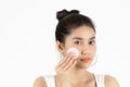 Pretty beauty young Asian woman cleaning her face with cotton pad over white isolated background. Healthy skin and cosmetics Royalty Free Stock Photo