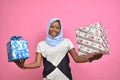 pretty black girl holding gift boxes and presents smiling and feeling excited Royalty Free Stock Photo