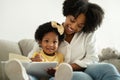 Pretty Black Mommy Reading Book With Her Cute Infant Daughter Royalty Free Stock Photo