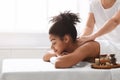 Pretty black woman enjoying body massage with aromatherapy Royalty Free Stock Photo