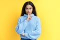 Pretty black woman keeps finger on lips, making hush gesture on yellow background Royalty Free Stock Photo