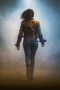 pretty black woman running away. foggy background at night. spooky dystopian and supernatural.