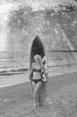 Pretty blond girl model like Marilyn Monroe with surfing board on a beach Royalty Free Stock Photo