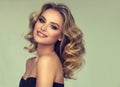 Pretty blond-haired model with curly, loose hairstyle and attractive makeup.