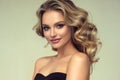 Pretty blond-haired model with curly, loose hairstyle and attractive makeup.