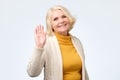 Senior woman waving her hand saying hello to her friend. Royalty Free Stock Photo