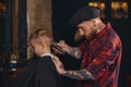 Caucasian boy getting haircut in barbershop indoor
