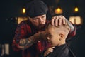 Caucasian boy getting haircut in barbershop indoor