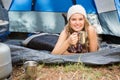 Pretty blonde camper smiling and lying in tent Royalty Free Stock Photo