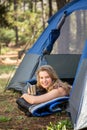 Pretty blonde camper smiling and lying in tent Royalty Free Stock Photo