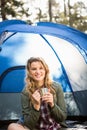 Pretty blonde camper smiling and sitting in tent Royalty Free Stock Photo