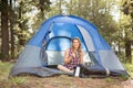 Pretty blonde camper smiling and sitting in tent Royalty Free Stock Photo