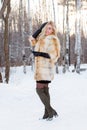 Pretty blonde in fur coat, leather gloves poses outdoor