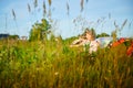 Pretty blonde girl and small boy with bright butterfly wings having fun in meadow or field on natural landscape with Royalty Free Stock Photo