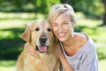 Pretty blonde with her dog in the park Royalty Free Stock Photo