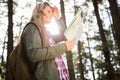 Pretty blonde hiker with map looking for path