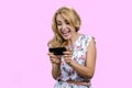 Pretty blonde mature woman playing online video game on her smartphone. Royalty Free Stock Photo