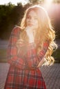 Pretty blonde model in fashionable checkered dress posing in ray Royalty Free Stock Photo