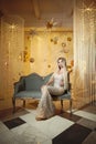 Pretty blonde model sitting on a vintage sofa Royalty Free Stock Photo
