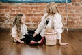Pretty blonde mother and her caucasian little daughter sitting on the floor with big box gift and happy together Royalty Free Stock Photo