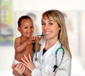 Pretty blonde pediatrician with a beautiful African American baby in arms Royalty Free Stock Photo