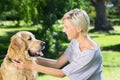 Pretty blonde playing with her dog in the park Royalty Free Stock Photo