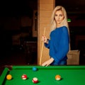 Pretty blonde woman with blue eyes plays billiard Royalty Free Stock Photo