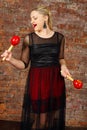 Pretty blonde woman in dress sings into maraca Royalty Free Stock Photo